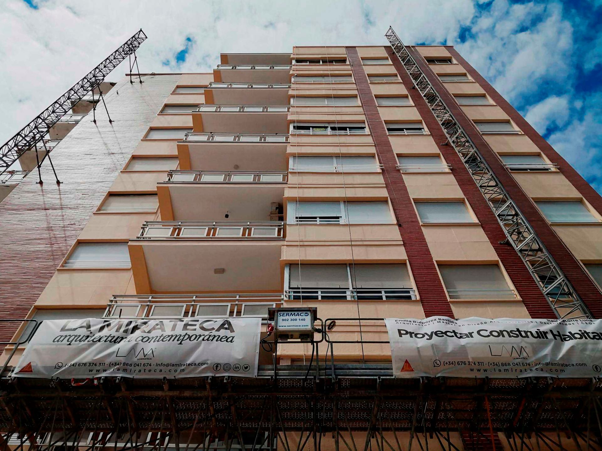 Restauración meticulosa de balcones y fachada en ladrillo caravista, revitalizando la esencia del Edificio Madrid